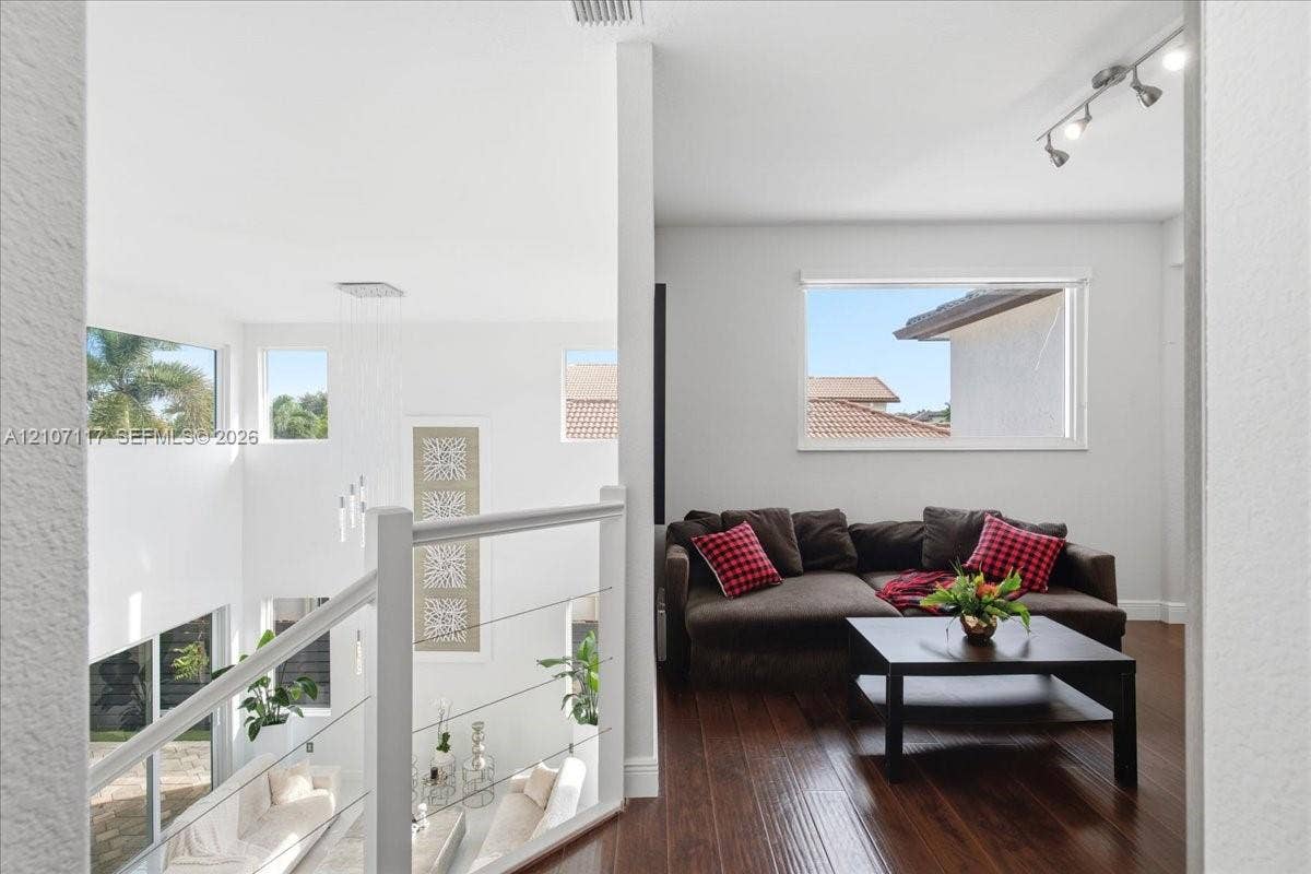 7863 NW 111th Court, Doral, FL 33178 Open mezzanine featuring wood-finish flooring, metal cable railing, recessed track lighting, and multi-level window placements