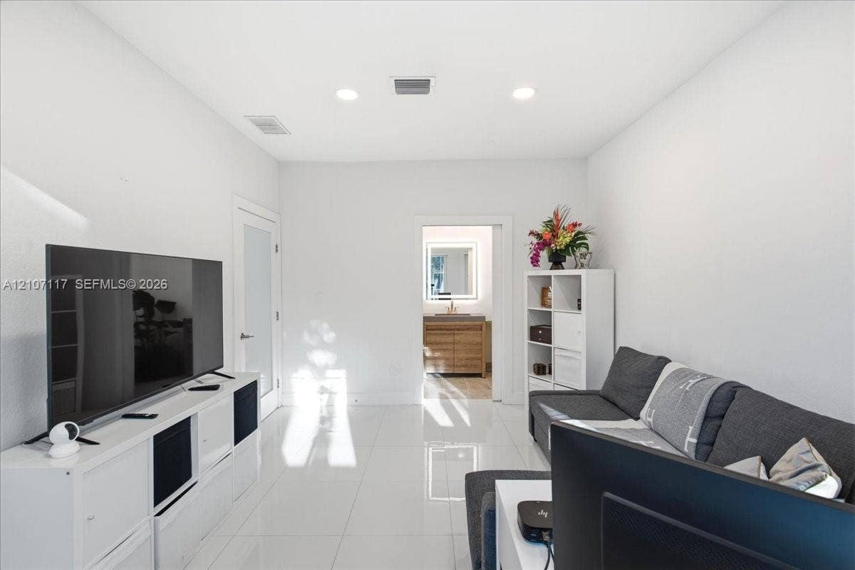 7863 NW 111th Court, Doral, FL 33178 High-gloss porcelain tile flooring, recessed ceiling lighting, and a frosted glass-panel interior door