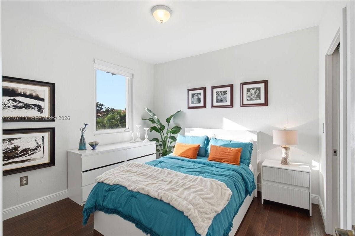 7863 NW 111th Court, Doral, FL 33178 Bedroom interior featuring dark wood-finish flooring, neutral wall tones, a single-hung window, and a flush-mount ceiling light fixture