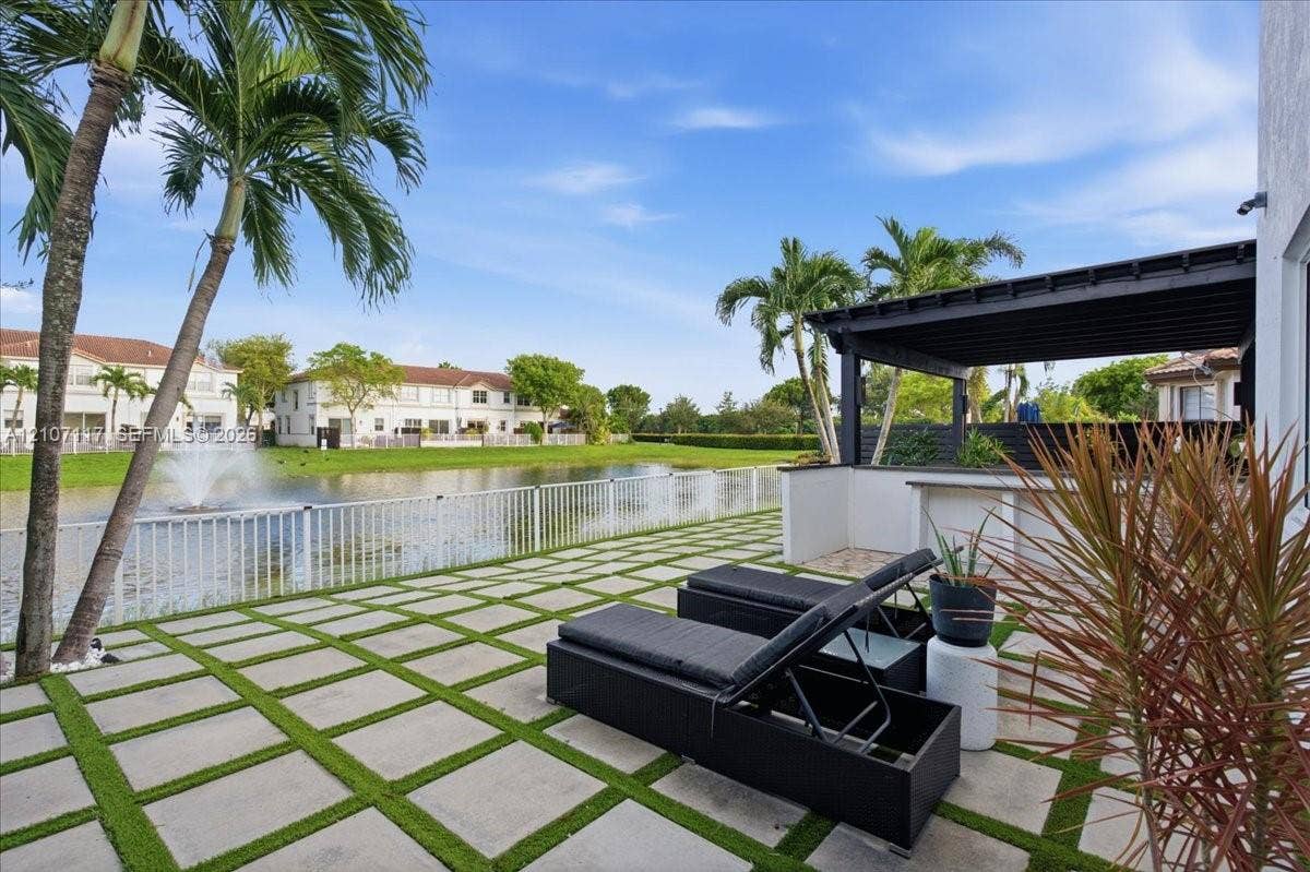 7863 NW 111th Court, Doral, FL 33178 Rear patio featuring concrete pavers with grass inlay, a built-in outdoor bar, and a covered pergola