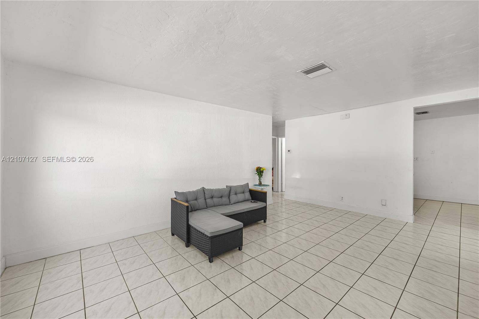 Neutral-toned interior featuring smooth white walls and ceramic tile flooring