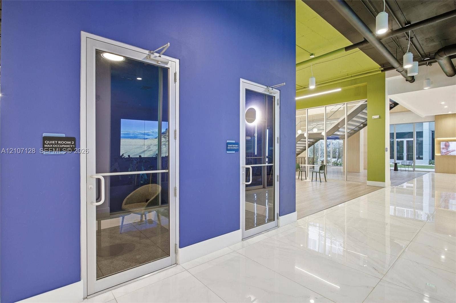 7875 NW 107th Avenue, #802, Doral, Doral, FL 33178 Enclosed glass-front rooms with polished tile flooring, contemporary color-blocked walls, exposed industrial-style ceilings, and pendant lighting