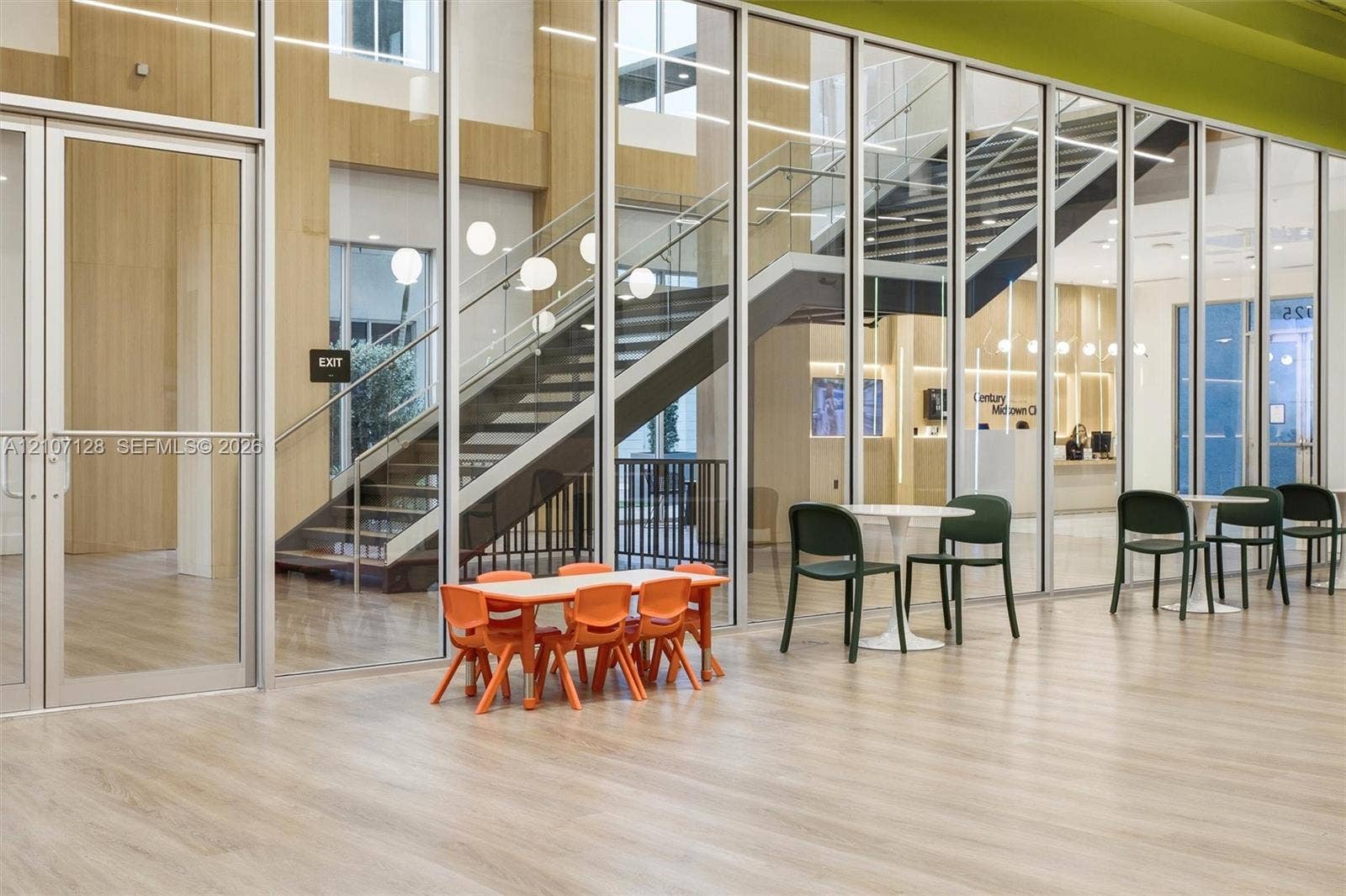 7875 NW 107th Avenue, #802, Doral, Doral, FL 33178 Expansive floor-to-ceiling glass wall partitions, wood-finish flooring, and an open staircase with metal handrails
