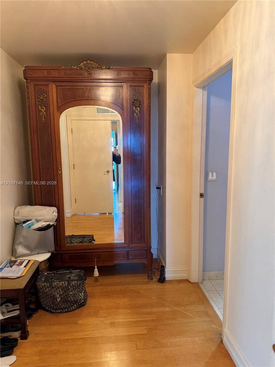 Hardwood flooring and a doorway featuring neutral-toned paint