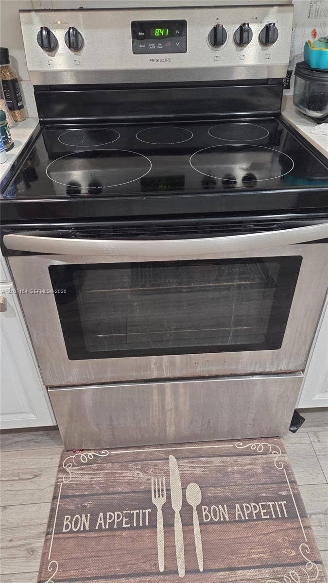 450 Commodore Drive, #311, Plantation, FL 33325 Stainless steel freestanding electric range with a glass cooktop, digital control panel, and full-width oven handle
