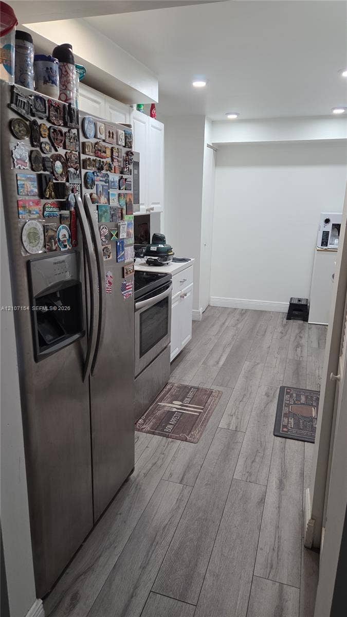 450 Commodore Drive, #311, Plantation, FL 33325 Kitchen featuring stainless steel appliances, white cabinetry, and wood-finish flooring with recessed lighting
