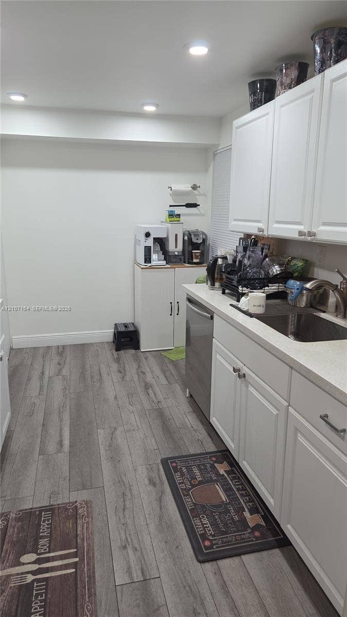 450 Commodore Drive, #311, Plantation, FL 33325 Kitchen featuring white shaker-style cabinetry, wood-finish flooring, recessed lighting, and a stainless steel undermount sink
