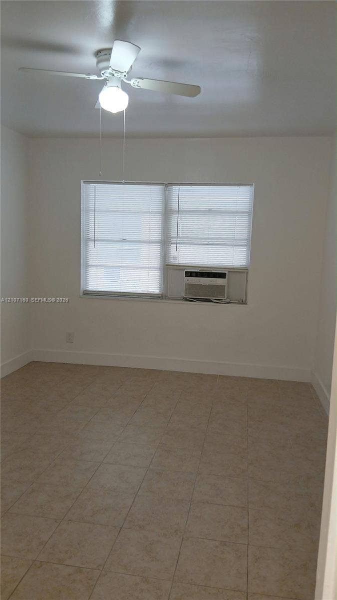325 NE 2nd Street, #2, Hallandale Beach, Hallandale Beach, FL 33009 Neutral-toned ceramic tile flooring, multi-pane window, and white ceiling fan with integrated lighting
