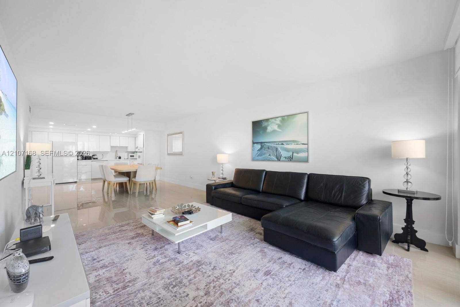Open floor plan featuring glossy tile flooring, recessed lighting, and kitchen cabinetry with a high-gloss finish
