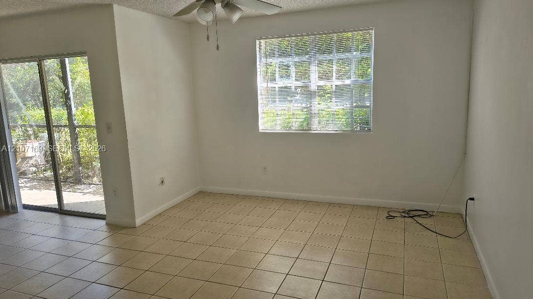 1267 SW 46th Avenue, #2311, Pompano Beach, Pompano Beach, FL 33069 Interior space featuring tile flooring, sliding glass door, multi-pane window, and ceiling fan with light fixture