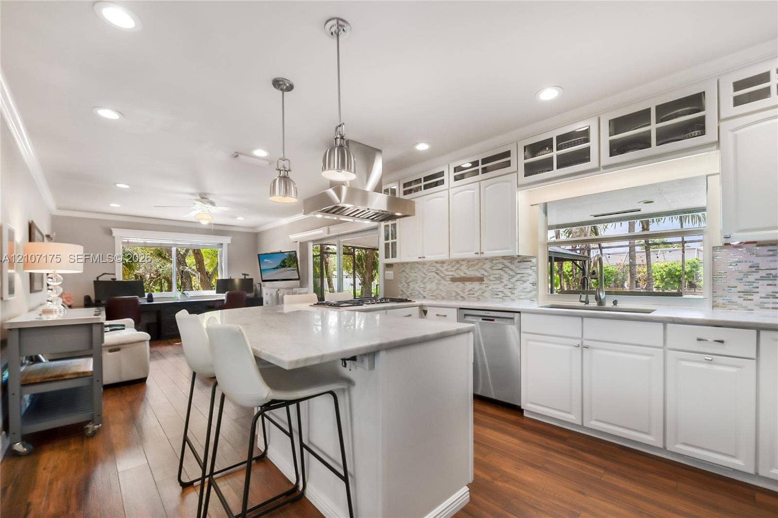17550 SW 86th Avenue, Palmetto Bay, FL 33157 Chefs kitchen featuring white shaker-style cabinetry, industrial pendants, a central island with granite.