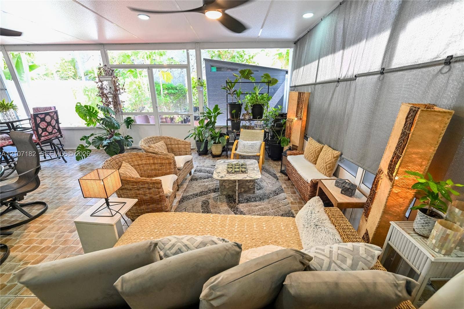 Screened-in patio featuring decorative tile flooring, ceiling-mounted fan, recessed lighting, and large screen panels
