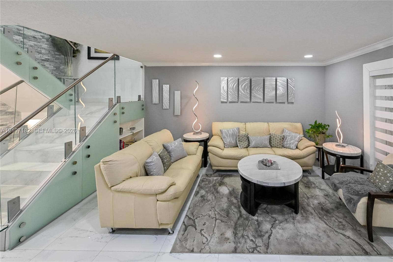 Staircase featuring glass panel railings, brushed metal hardware, and stone-finish steps