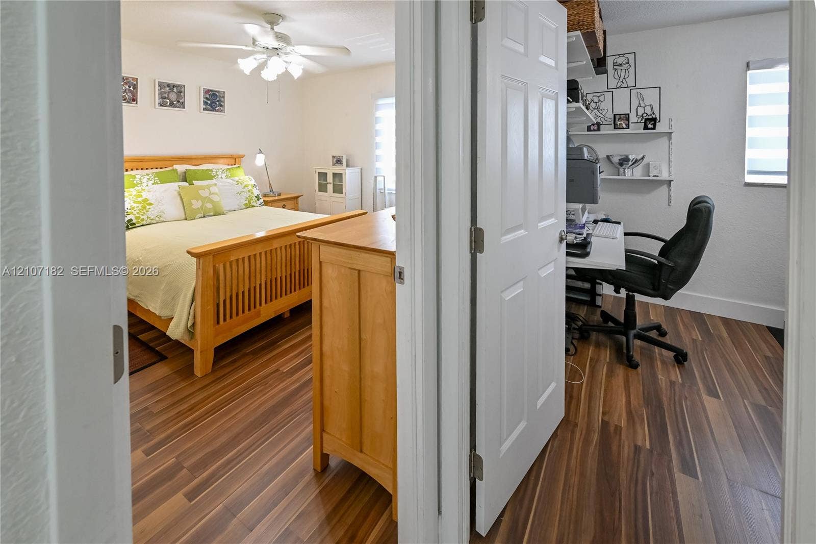 Wood-finish flooring throughout, ceiling-mounted light fixture with fan, and white paneled doors