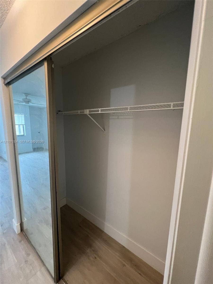 240 Lakeview Drive, #209, Weston, Weston, FL 33326 Closet featuring sliding mirror doors, metal wire shelving, and wood-finish flooring