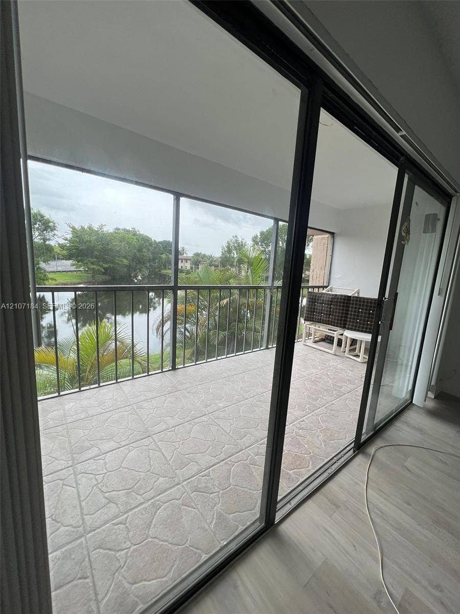 240 Lakeview Drive, #209, Weston, Weston, FL 33326 Screened balcony featuring tiled flooring, a metal railing, and water frontage