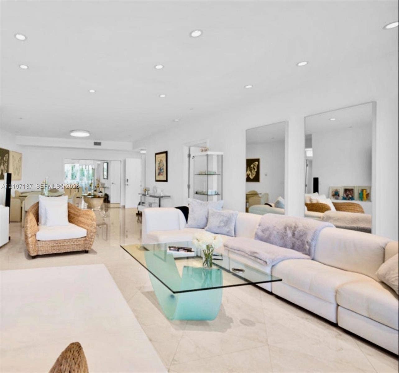9601 Collins Avenue, #403, Bal Harbour, FL 33154 Open-concept living space featuring high-gloss tile flooring, recessed lighting, and large wall-mounted mirrors