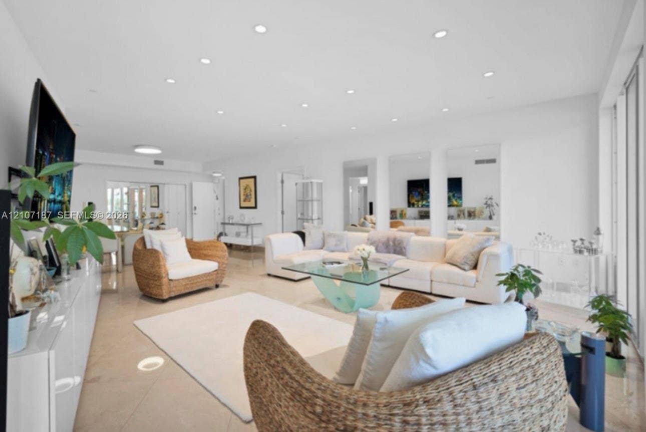 9601 Collins Avenue, #403, Bal Harbour, FL 33154 Open-concept interior featuring large-format tile flooring, recessed ceiling lighting, and three floor-to-ceiling wall mirrors