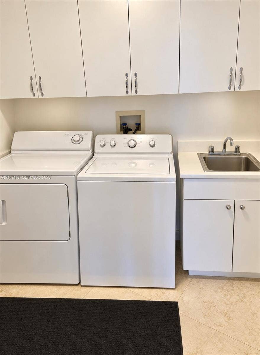 9601 Collins Avenue, #403, Bal Harbour, FL 33154 Laundry area featuring white cabinetry, a built-in utility sink with a stone-finish countertop, and tiled flooring