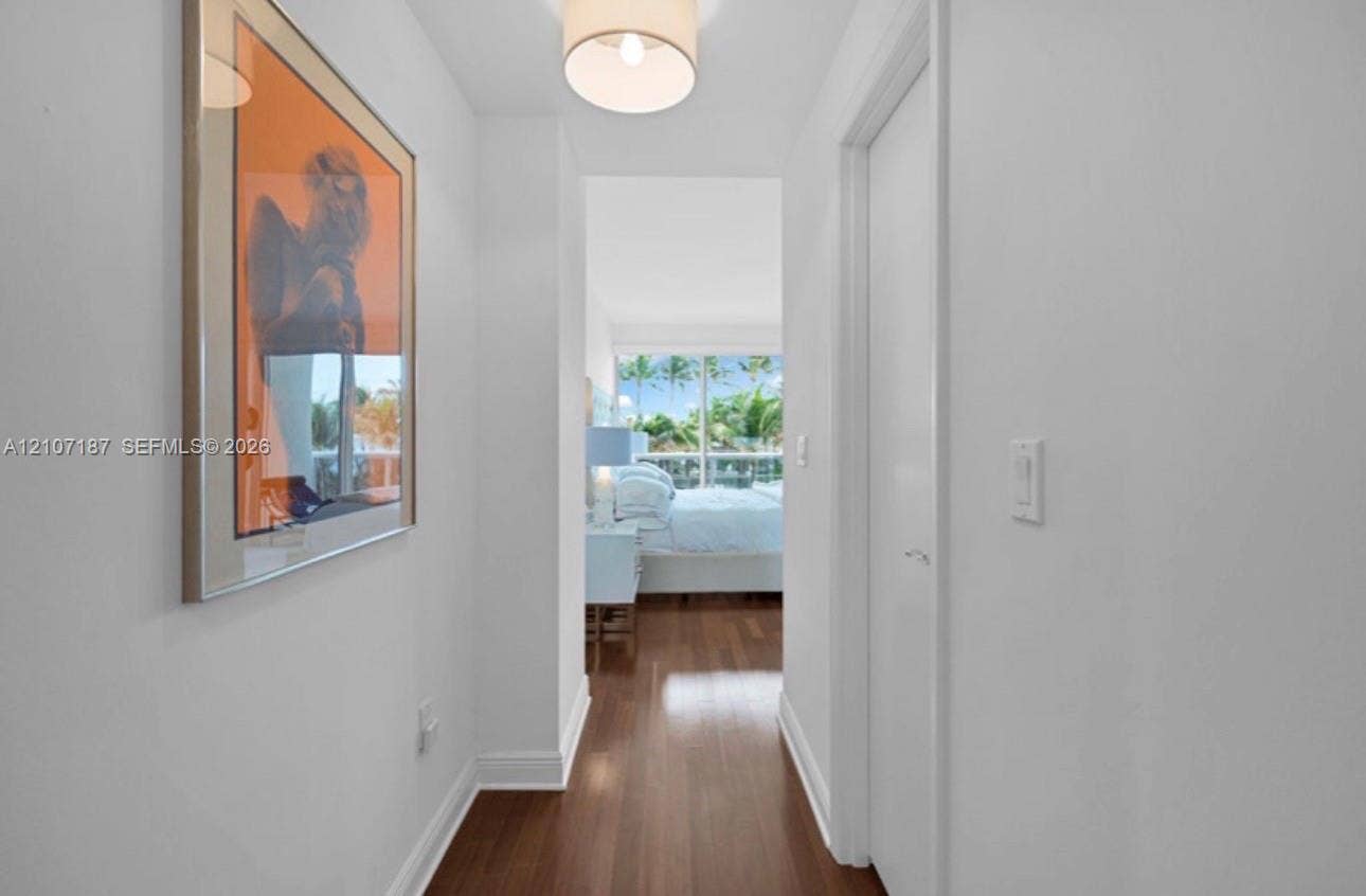 9601 Collins Avenue, #403, Bal Harbour, FL 33154 Hallway featuring wood-finish flooring, a drum-style overhead light fixture, and a full-height closet door