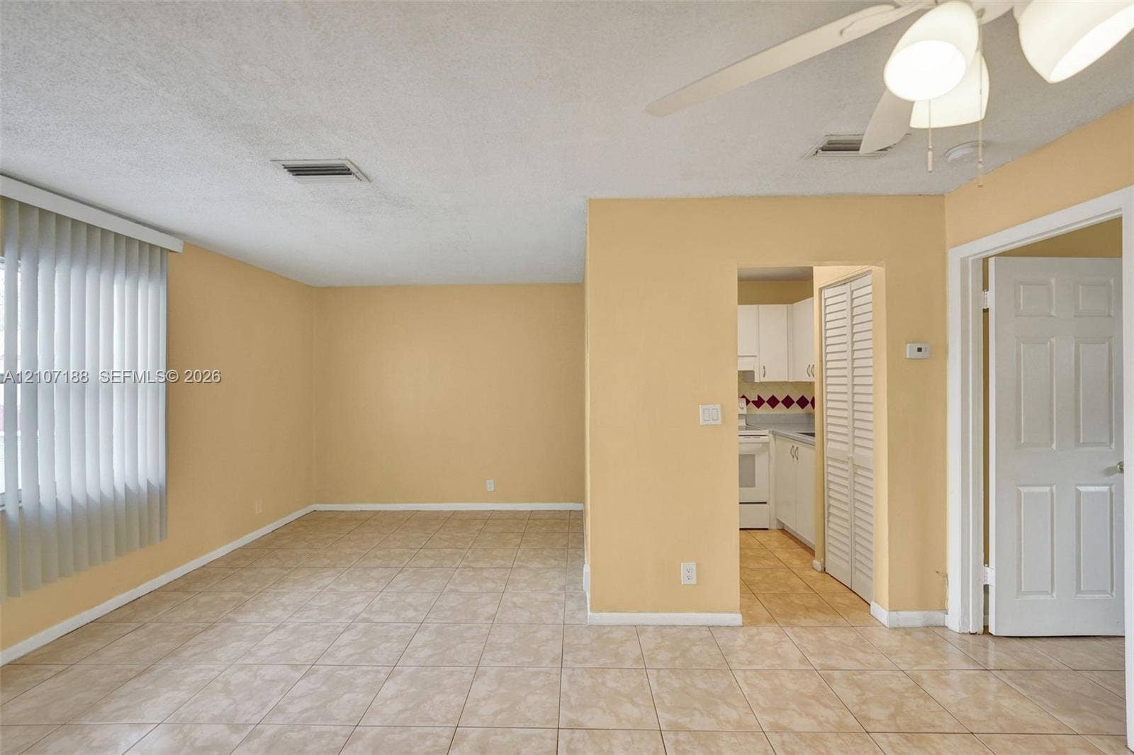 10301 NW 36th Street, #2, Coral Springs, Coral Springs, FL 33065 Interior space featuring neutral-toned walls, tile flooring, vertical window blinds, a ceiling fan with light fixture, and louvered closet doors