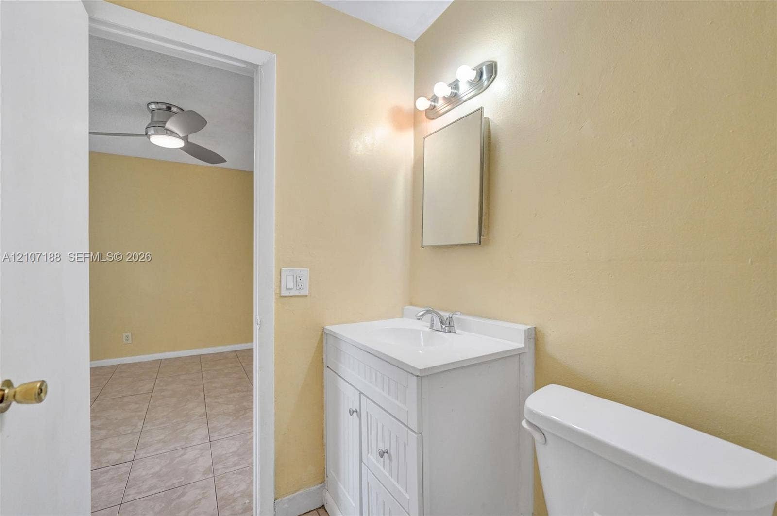 10301 NW 36th Street, #2, Coral Springs, Coral Springs, FL 33065 Bathroom featuring a white vanity cabinet with beadboard paneling, an integrated white sink, a chrome faucet, a wall-mounted medicine cabinet, and a multi-bulb vanity light fixture