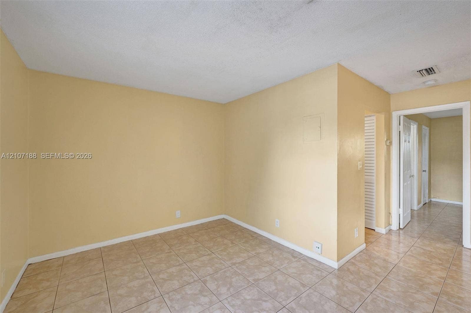 10301 NW 36th Street, #2, Coral Springs, Coral Springs, FL 33065 Interior space featuring neutral wall paint, large-format ceramic tile flooring, and louvered bifold closet doors