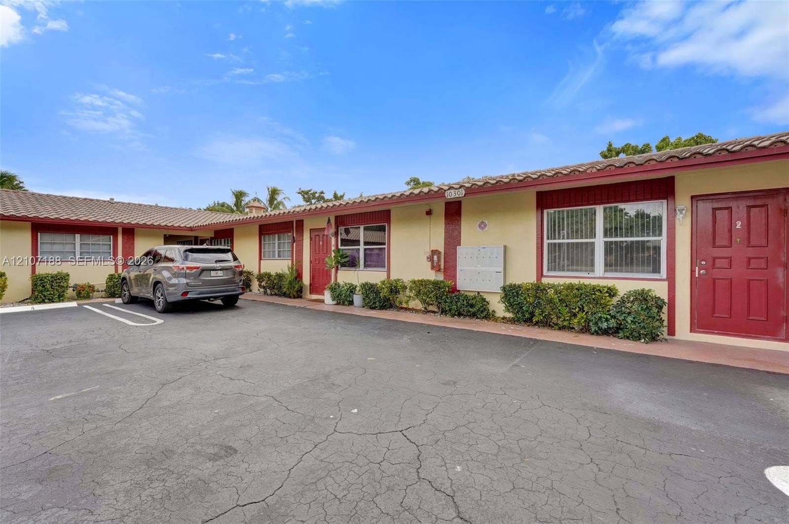 10301 NW 36th Street, #2, Coral Springs, Coral Springs, FL 33065 Single-story exterior featuring a tile roof, paved parking area, and manicured shrubbery