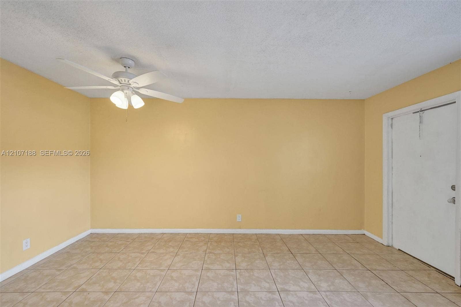 10301 NW 36th Street, #2, Coral Springs, Coral Springs, FL 33065 Interior room featuring neutral-toned tile flooring, light-colored wall paint, and a white ceiling fan with integrated lighting