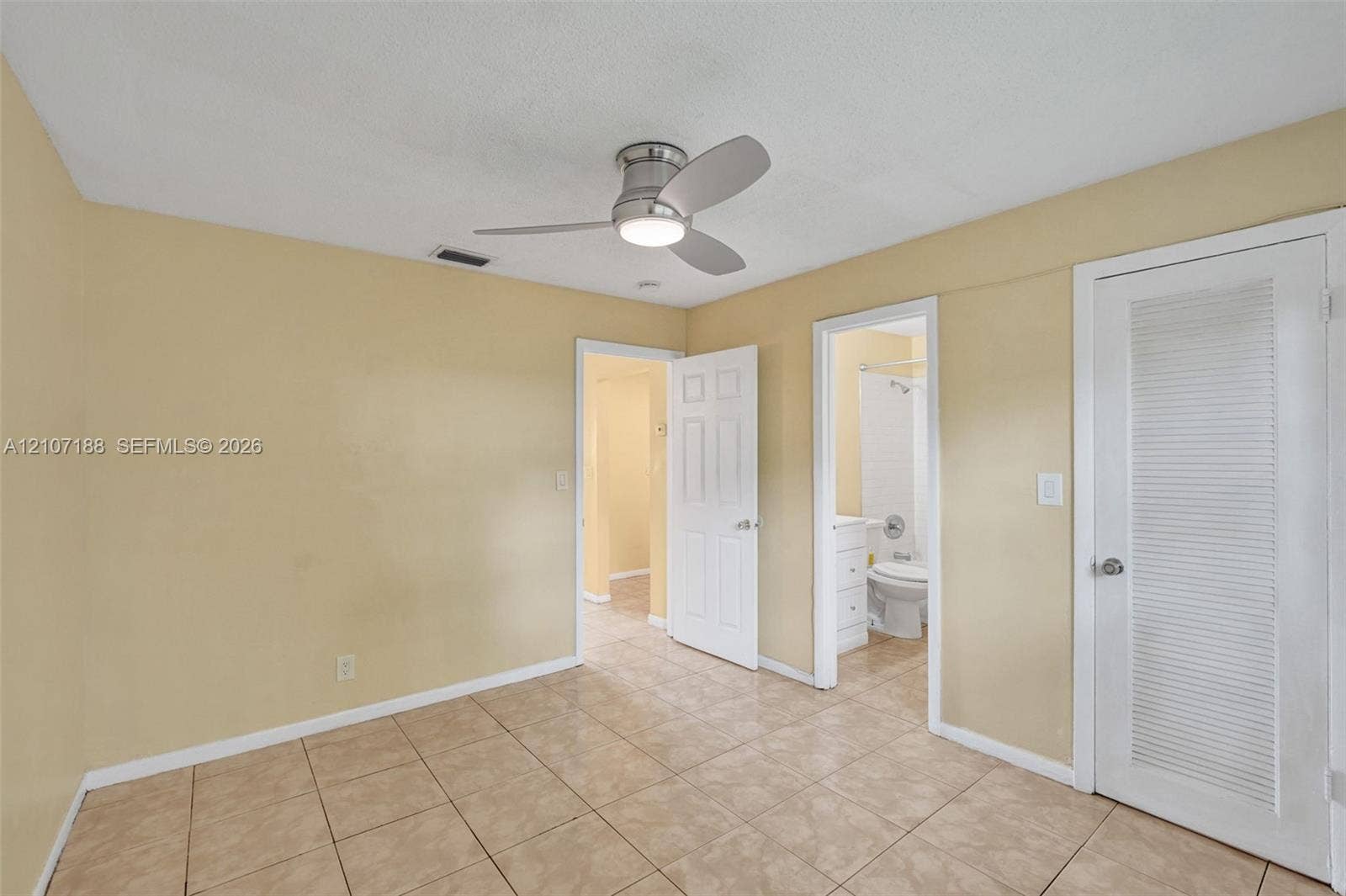 10301 NW 36th Street, #2, Coral Springs, Coral Springs, FL 33065 Room featuring tile flooring, a brushed nickel ceiling fan with integrated lighting, and louvered closet doors