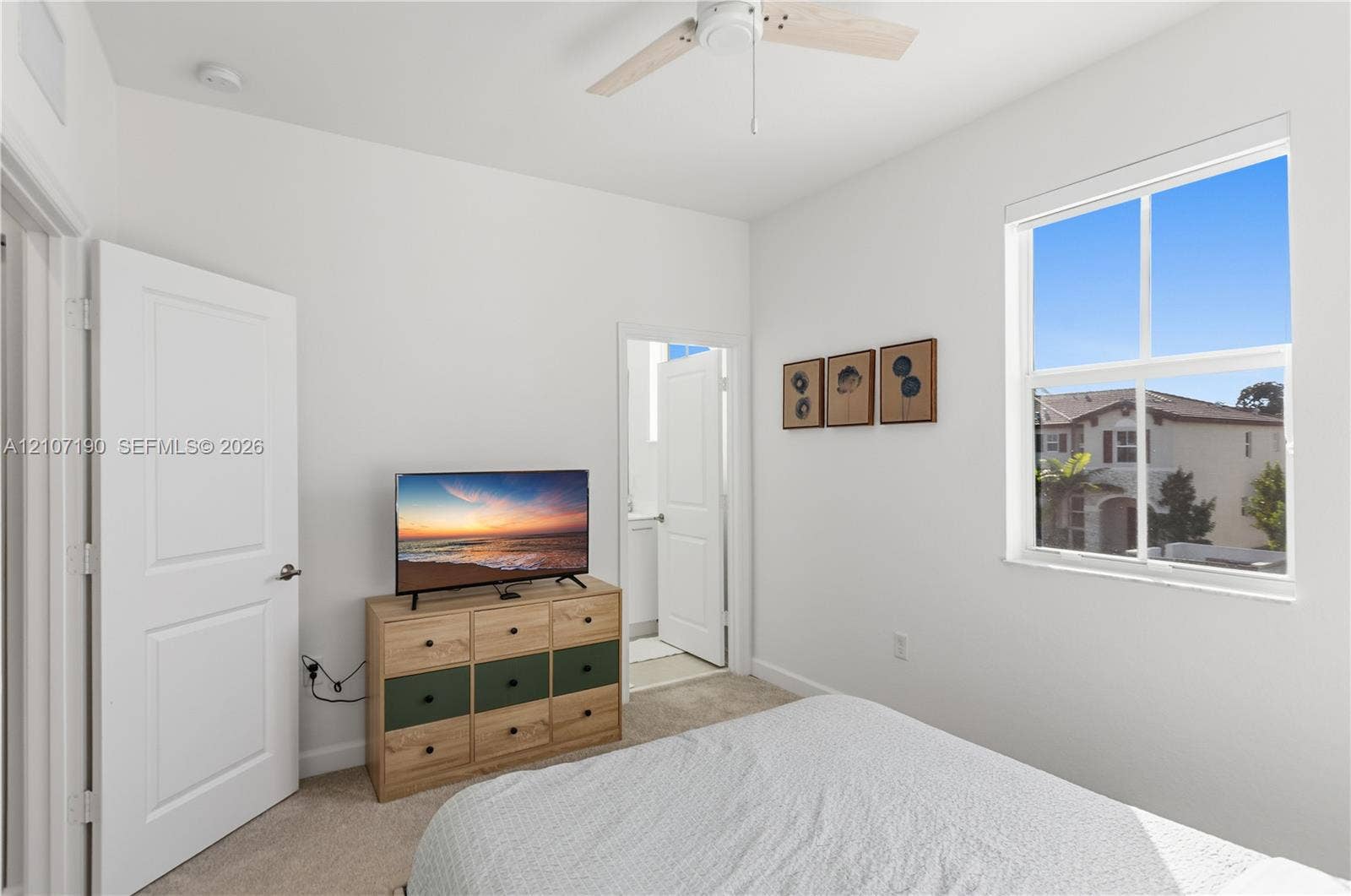 Room featuring neutral carpeting, a dual-pane window, and a ceiling fan with light fixture