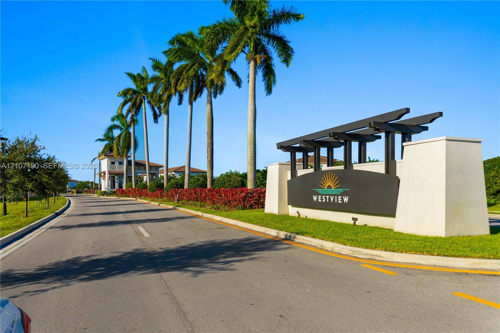 Community entrance monument featuring a structural steel header, stucco pillars, and native palm landscaping