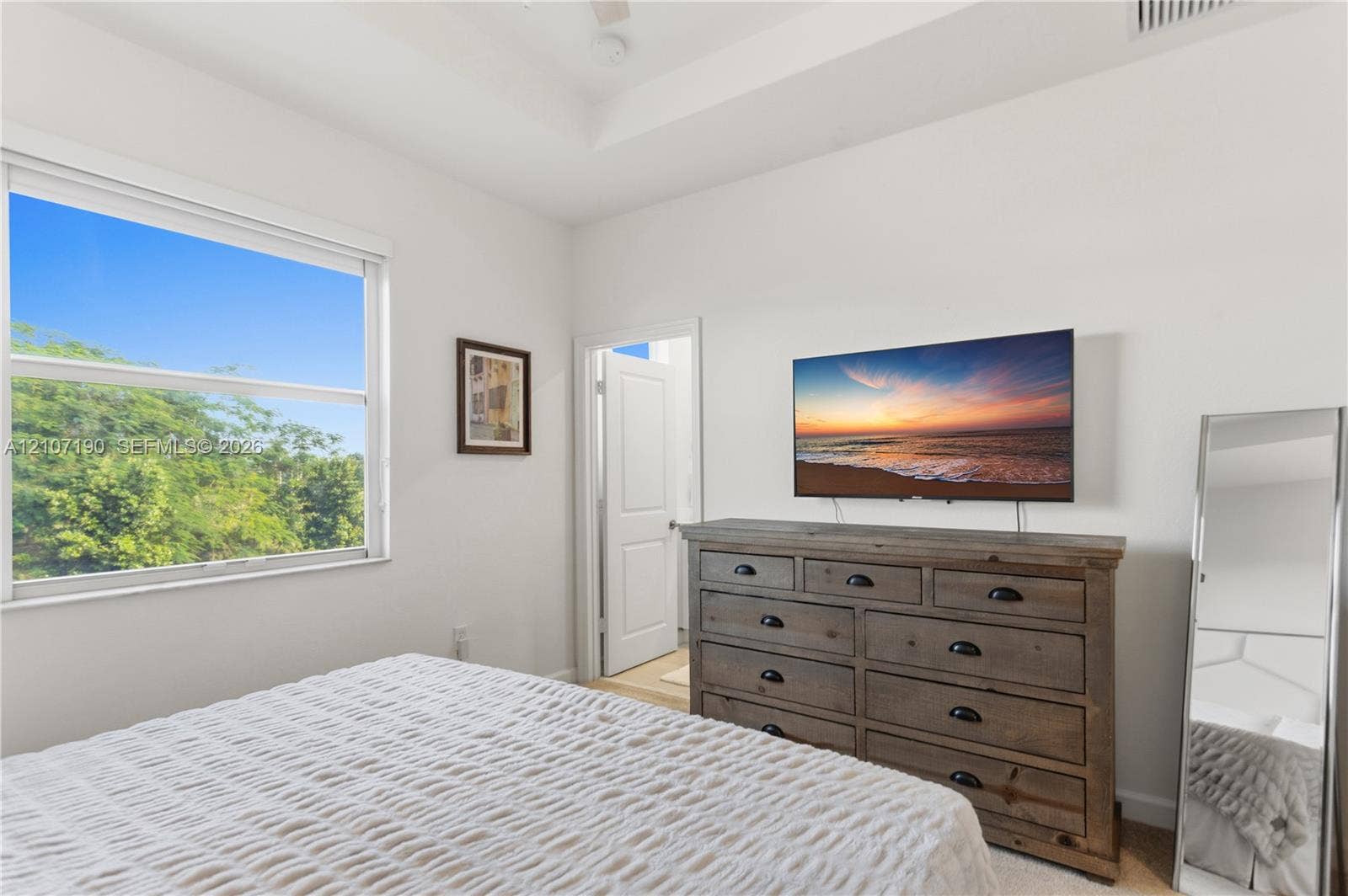 Tray ceiling featuring crisp white paint and a wide-format window