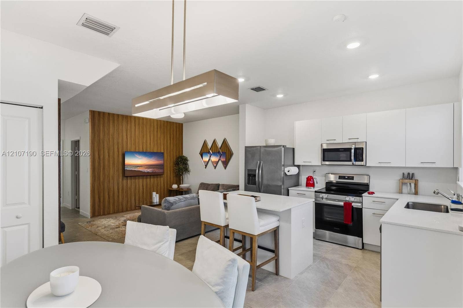 Kitchen featuring flat-panel cabinetry, stainless steel appliances, and a solid-surface center island