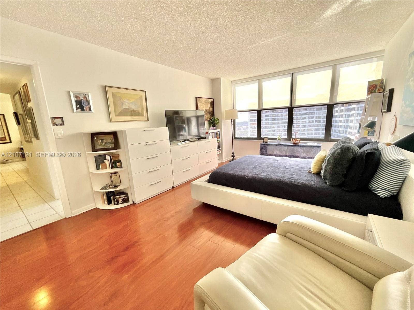 Wood-finish flooring, expansive floor-to-ceiling windows, and recessed ceiling lighting