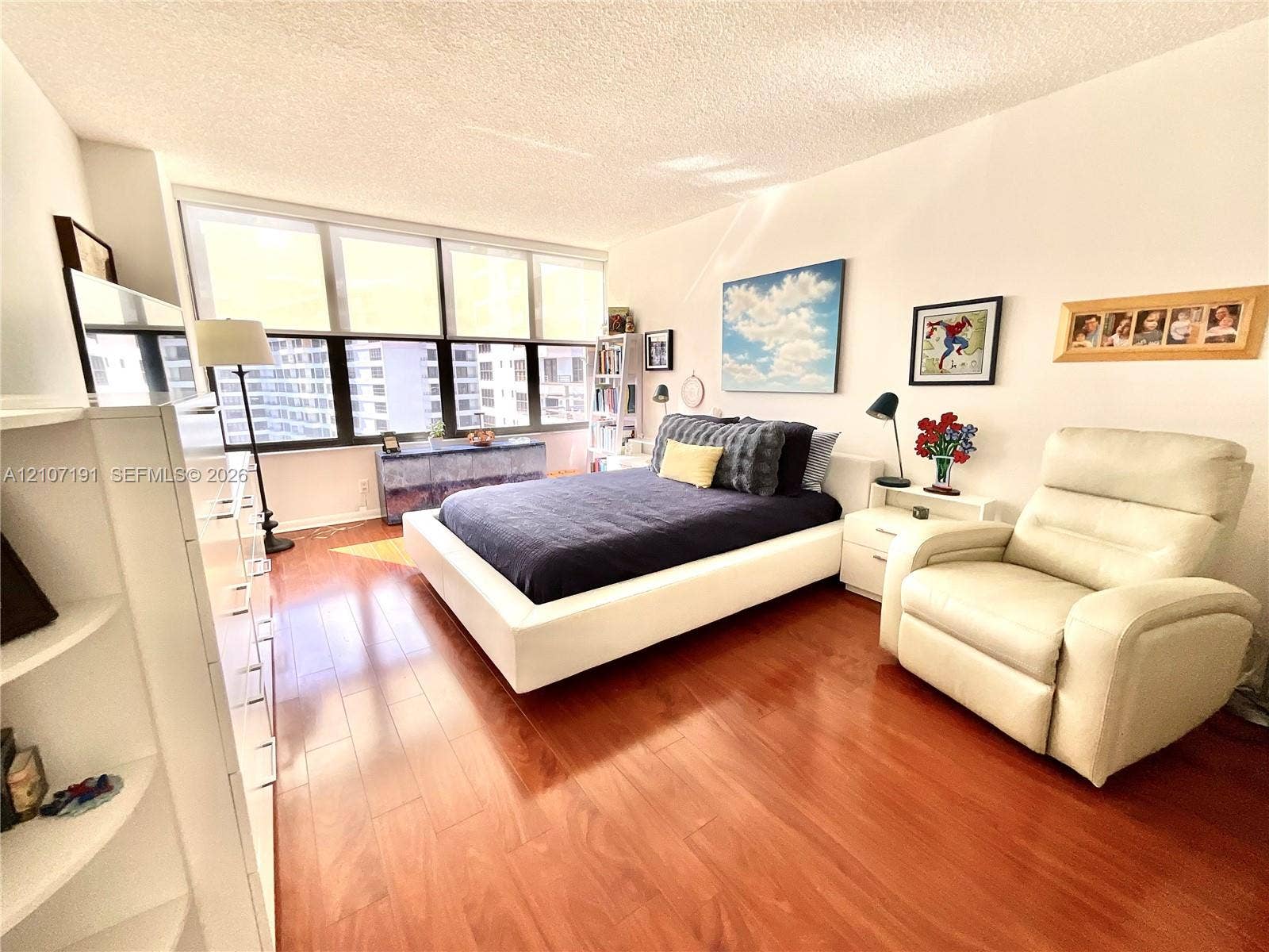 Expansive floor-to-ceiling windows, wood-finish flooring, and a neutral color palette