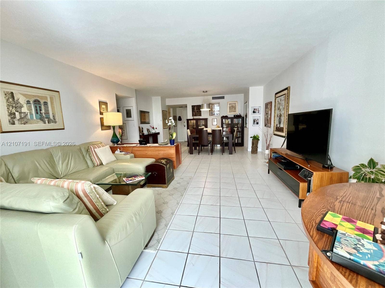Large open-concept living area featuring neutral wall paint, oversized ceramic tile flooring, and recessed ceiling lighting