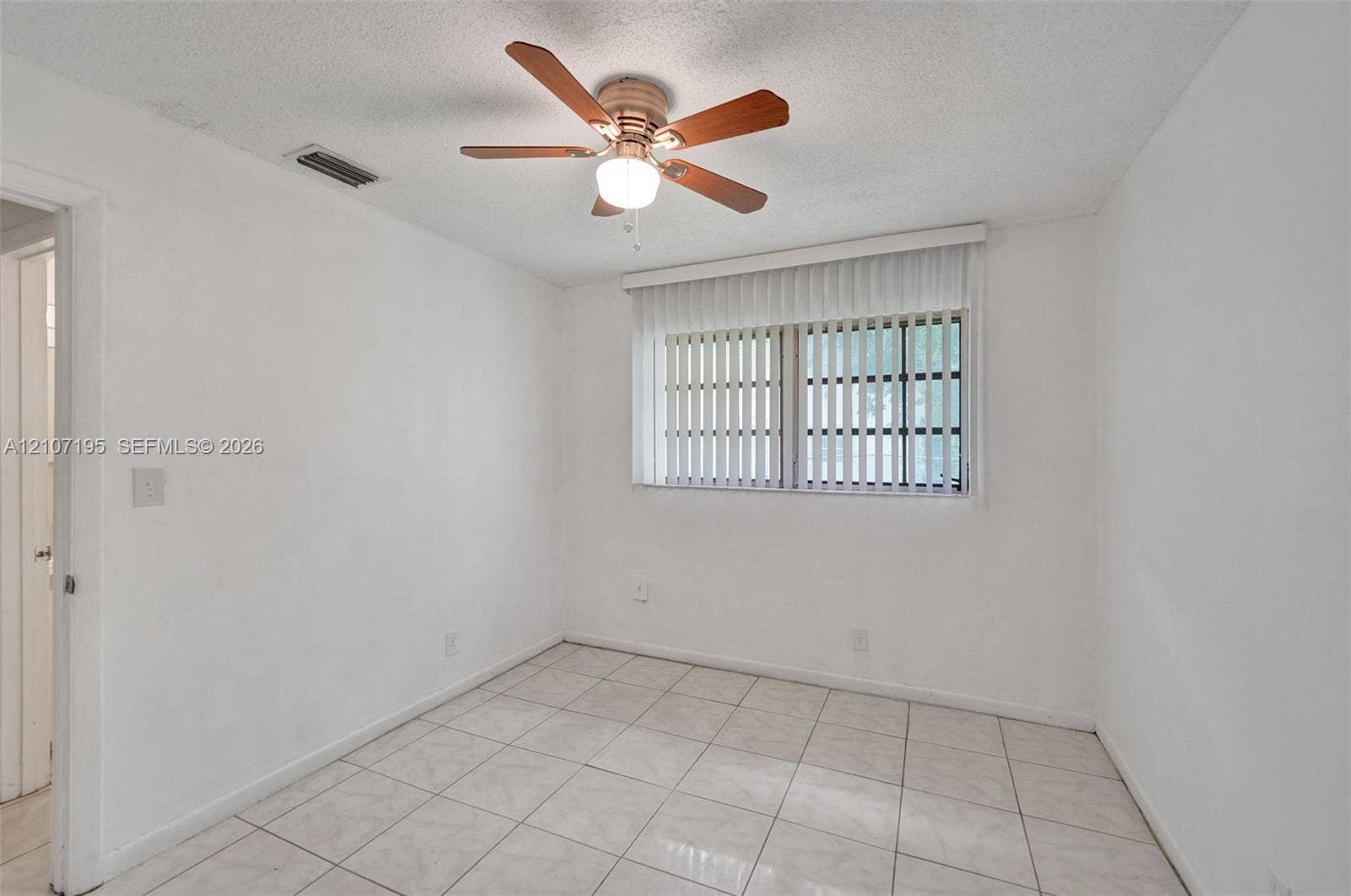10301 NW 36th Street, #5, Coral Springs, Coral Springs, FL 33065 Room interior featuring neutral tile flooring, a multi-blade ceiling fan with integrated lighting, and vertical window blinds