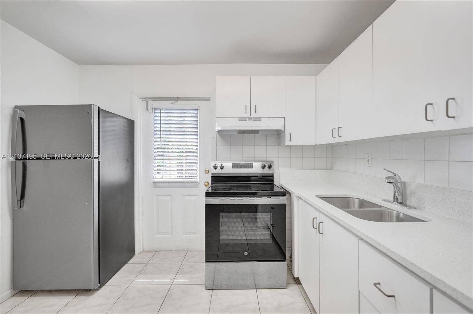 10301 NW 36th Street, #5, Coral Springs, Coral Springs, FL 33065 Kitchen featuring white cabinetry, solid-surface countertops, stainless steel appliances, tile backsplash, and ceramic tile flooring