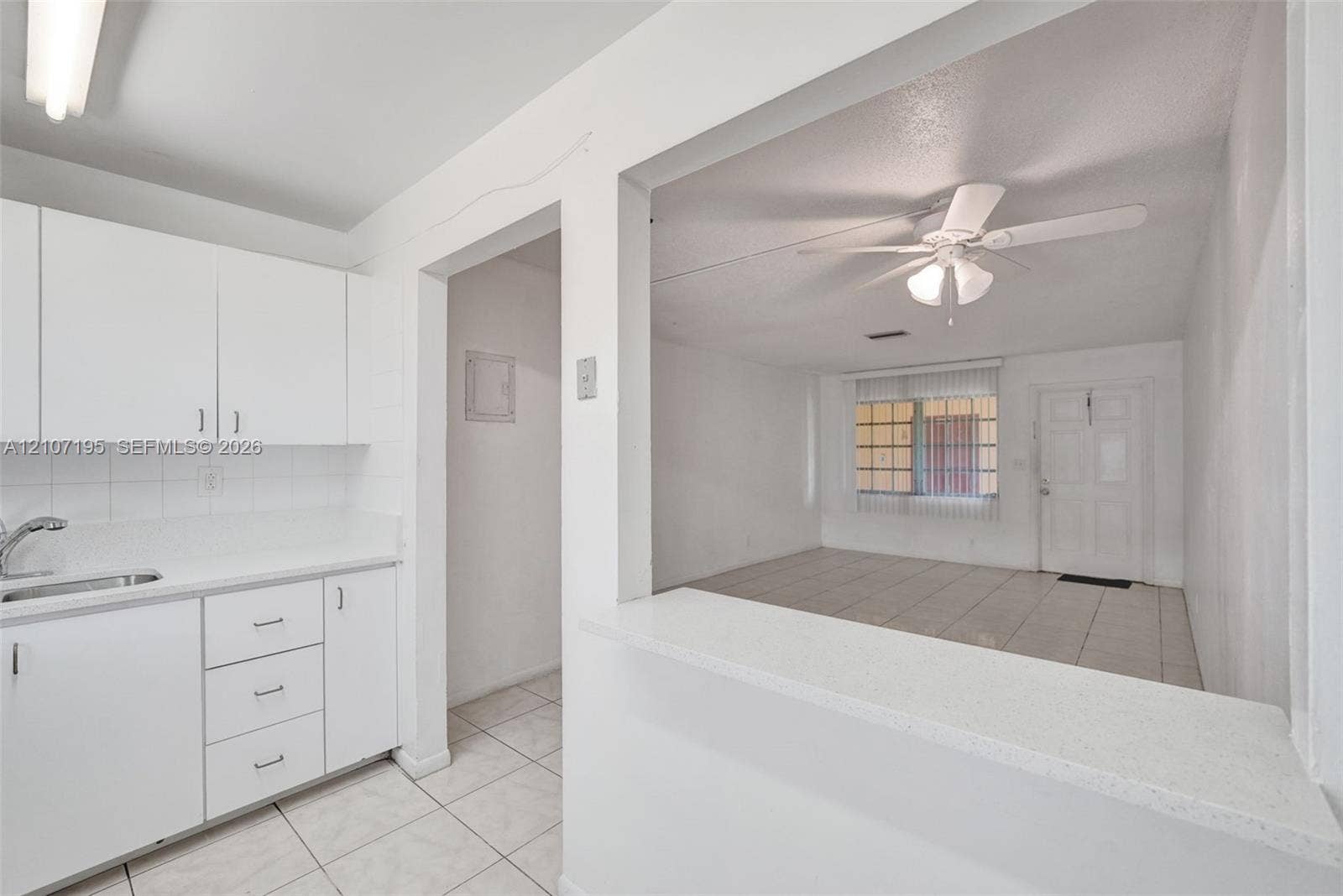 10301 NW 36th Street, #5, Coral Springs, Coral Springs, FL 33065 Kitchen featuring white cabinetry, a solid-surface pass-through counter, and ceramic tile flooring throughout the main area