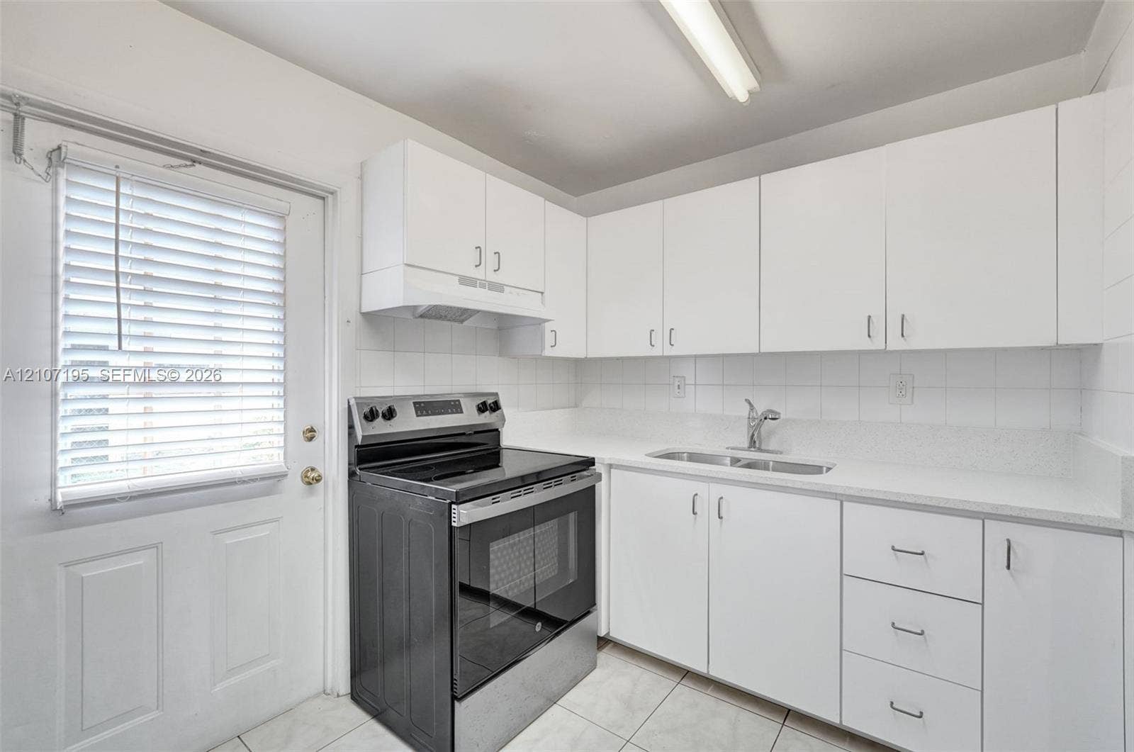 10301 NW 36th Street, #5, Coral Springs, Coral Springs, FL 33065 Kitchen featuring white cabinetry, light-toned countertops, tile backsplash, stainless steel range, and dual-basin stainless steel sink