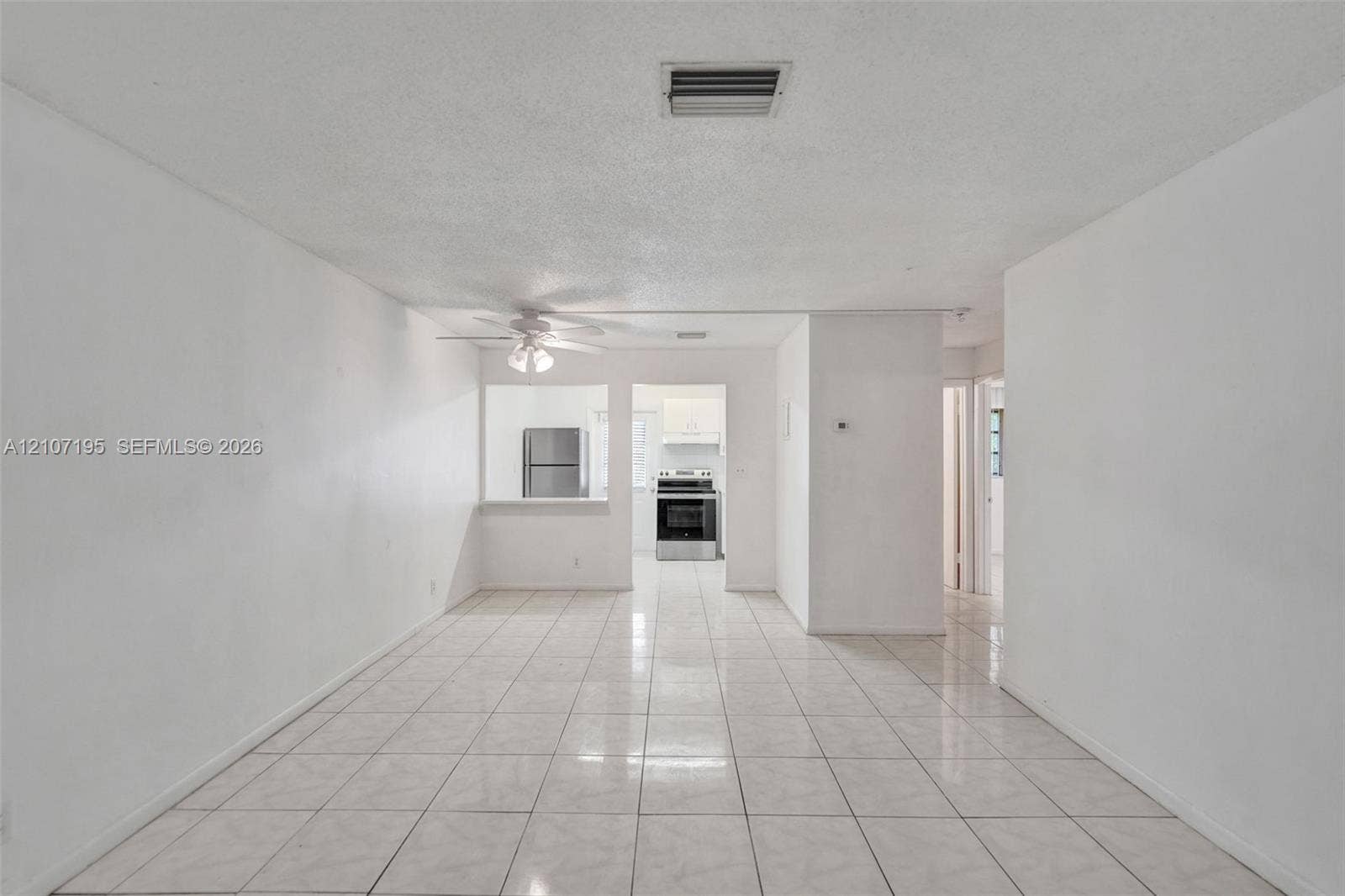 10301 NW 36th Street, #5, Coral Springs, Coral Springs, FL 33065 Interior space featuring neutral wall tones, large-format ceramic tile flooring, and a ceiling-mounted fan
