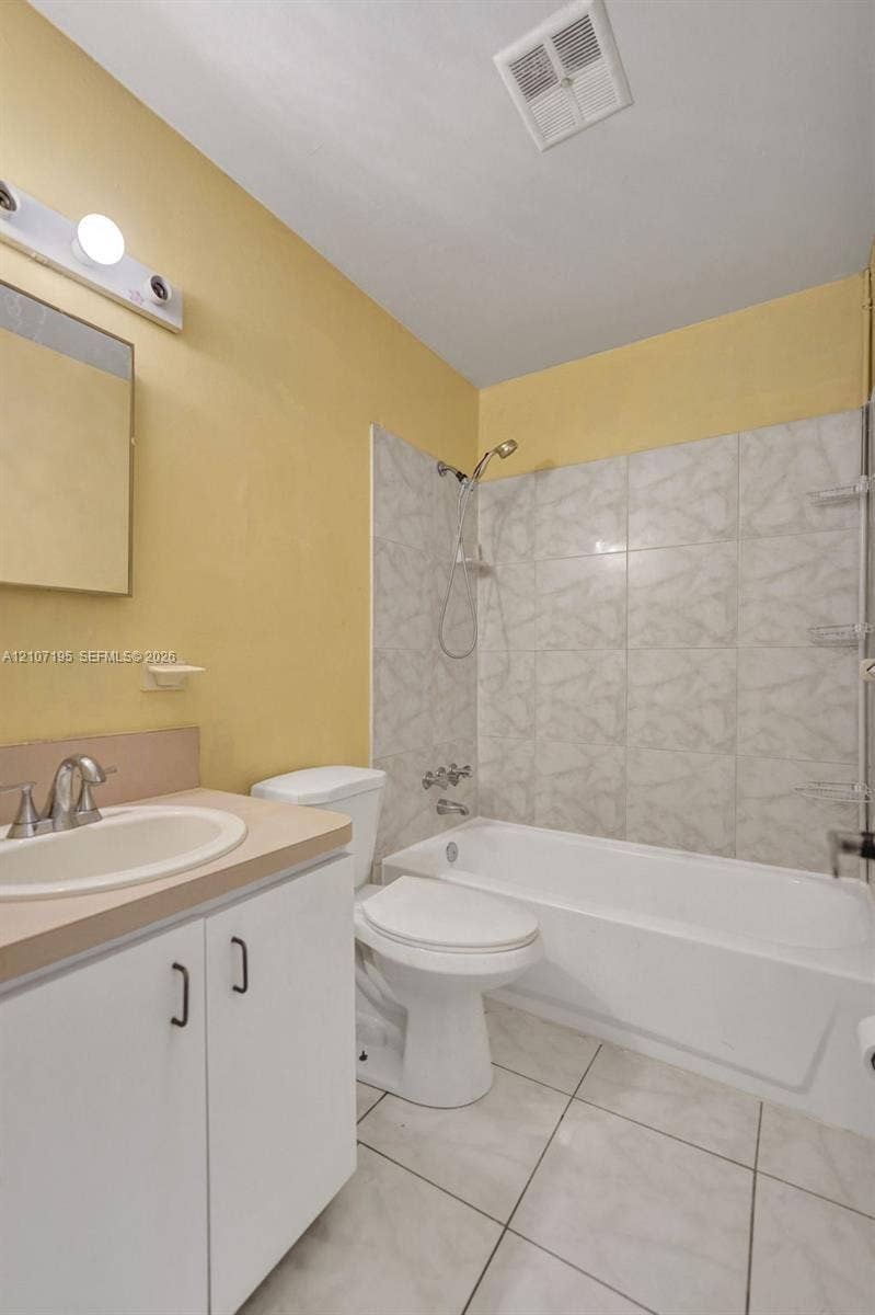 10301 NW 36th Street, #5, Coral Springs, Coral Springs, FL 33065 Bathroom featuring white cabinetry, integrated sink, tiled tub surround, and tile flooring