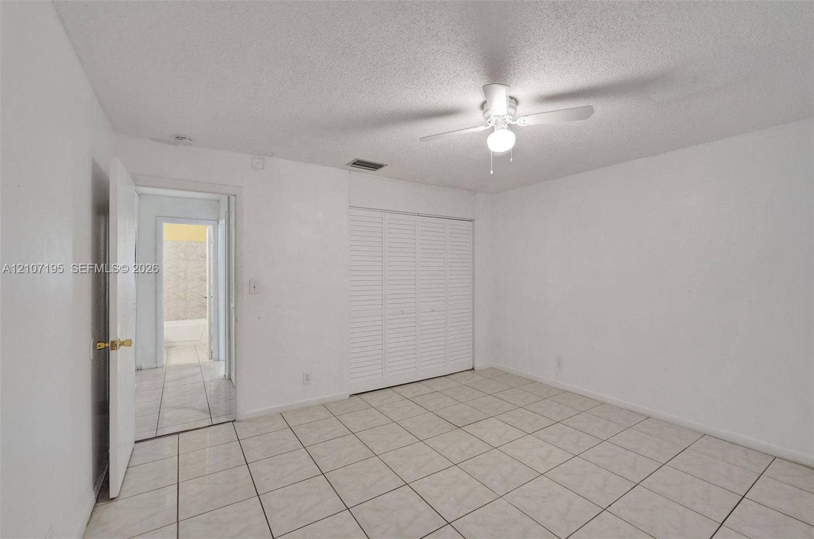 10301 NW 36th Street, #5, Coral Springs, Coral Springs, FL 33065 Tile flooring, ceiling-mounted light fixture with fan, and white louvered closet doors
