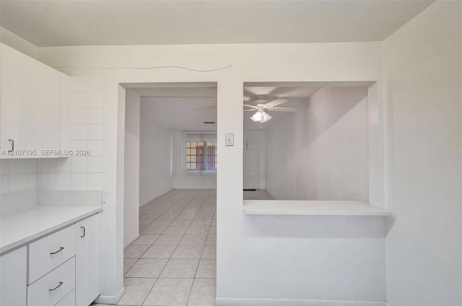 10301 NW 36th Street, #5, Coral Springs, Coral Springs, FL 33065 Kitchen featuring white cabinetry, a light-toned countertop, and a pass-through window with a ledge