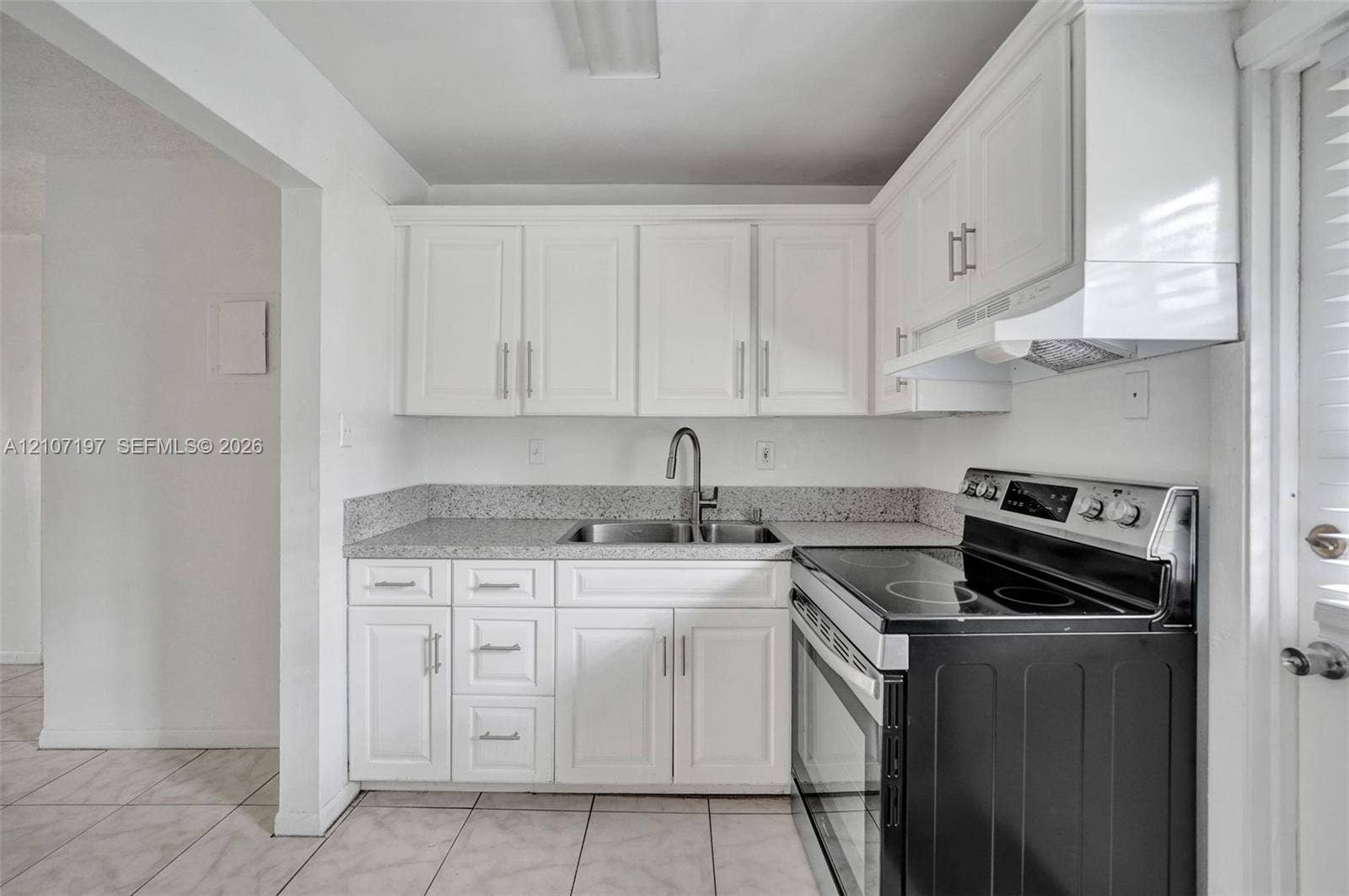 10301 NW 36th Street, #6, Coral Springs, Coral Springs, FL 33065 Kitchen featuring white shaker-style cabinetry, stone-finish countertops, stainless steel undermount sink with a gooseneck faucet, black electric range, and tiled flooring