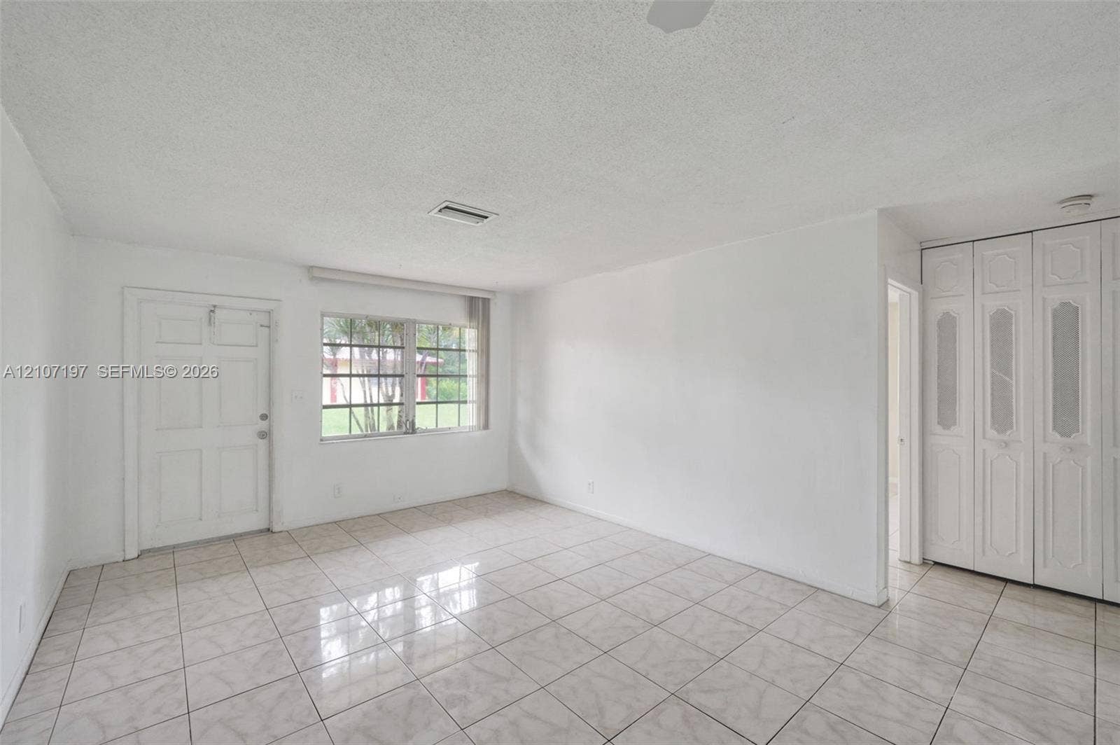 10301 NW 36th Street, #6, Coral Springs, Coral Springs, FL 33065 Ceramic tile flooring, white paneled entry door, multi-pane window, and floor-to-ceiling built-in closet with decorative paneling