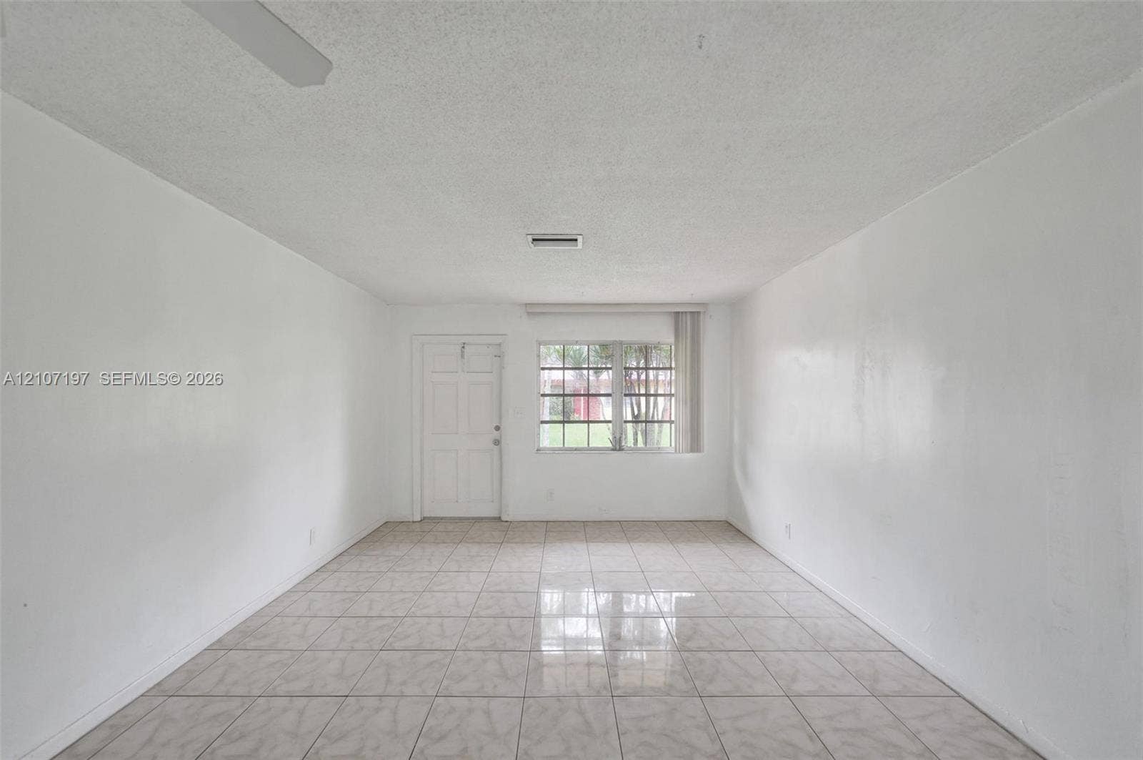 10301 NW 36th Street, #6, Coral Springs, Coral Springs, FL 33065 Interior space featuring neutral wall tones, large-format ceramic tile flooring, a multi-pane window, and a paneled entry door
