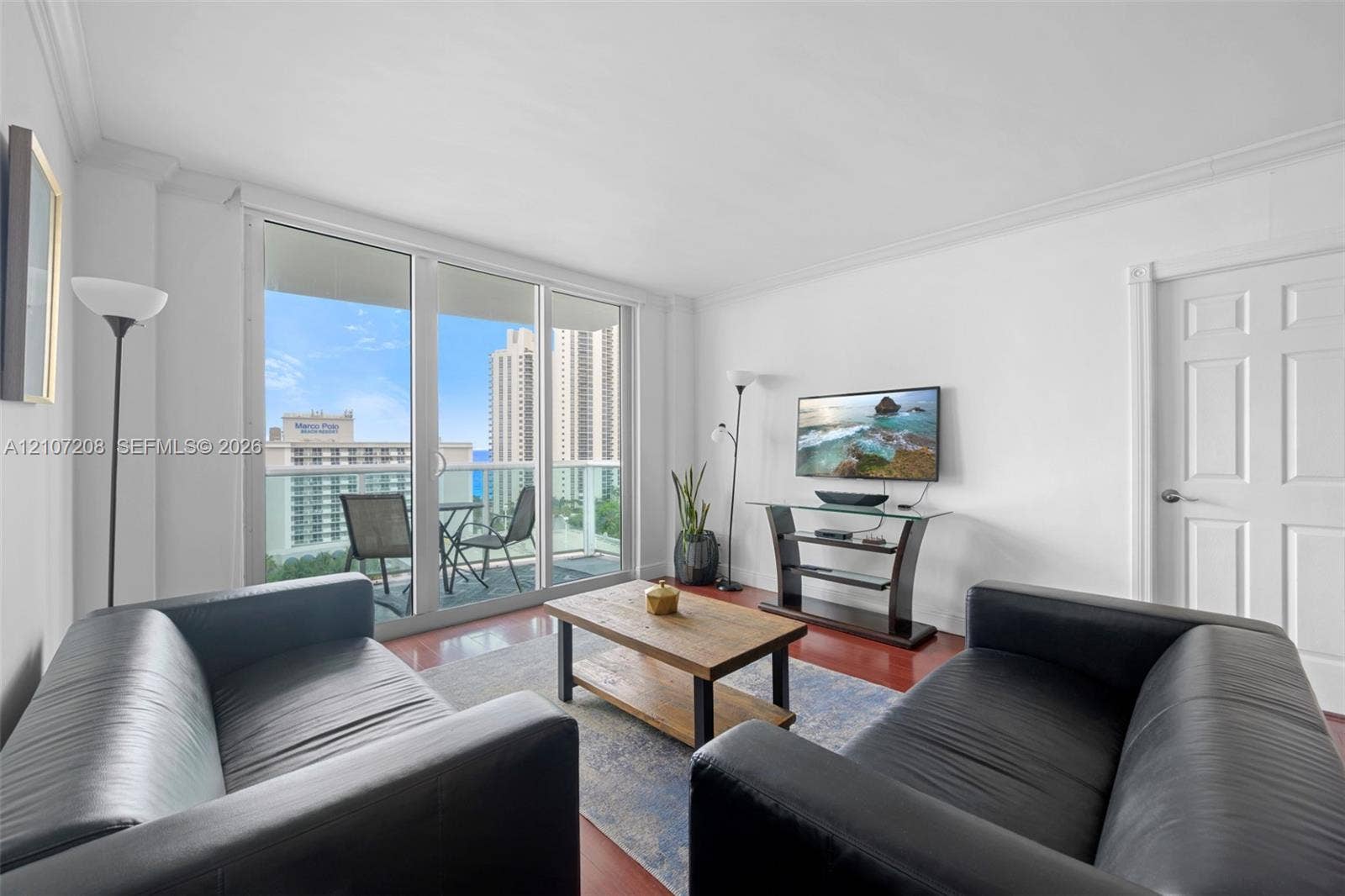 19370 Collins Avenue, #1405, Sunny Isles Beach, Sunny Isles Beach, FL 33160 Living space featuring floor-to-ceiling glass sliding doors, private balcony access, and wood-finish flooring