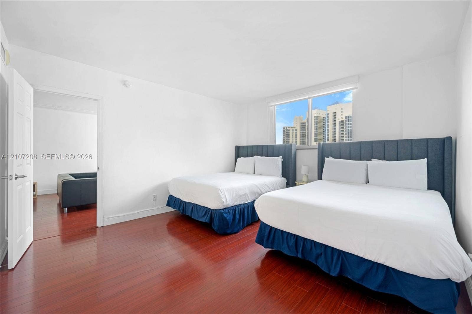 19370 Collins Avenue, #1405, Sunny Isles Beach, Sunny Isles Beach, FL 33160 Room featuring wood-finish flooring, a neutral color palette, and a large window with urban scenery